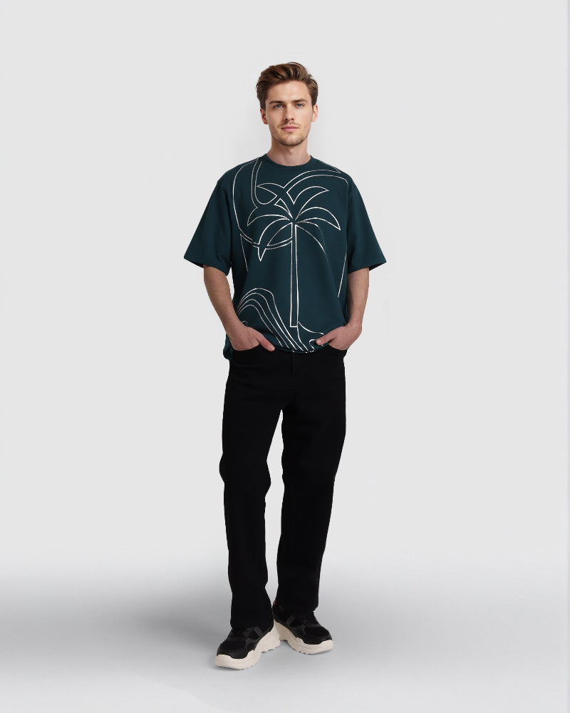 Man wearing a dark green t-shirt with a palm tree design on a white background