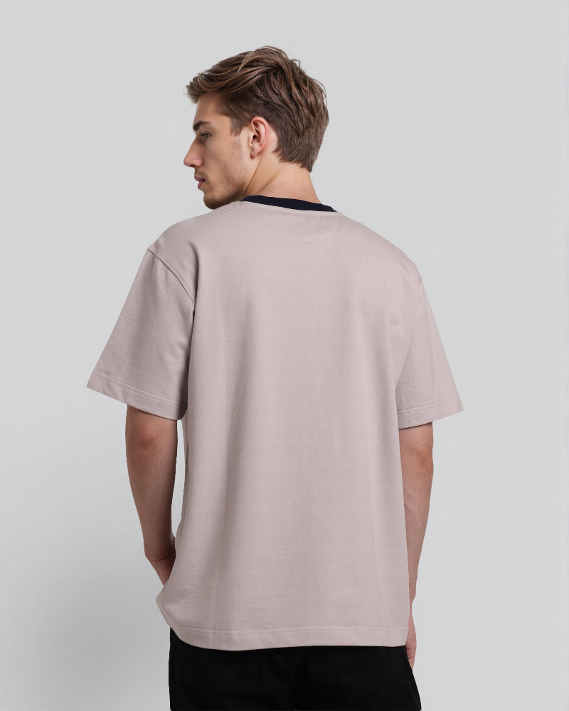 Man wearing a light gray t-shirt on a plain background