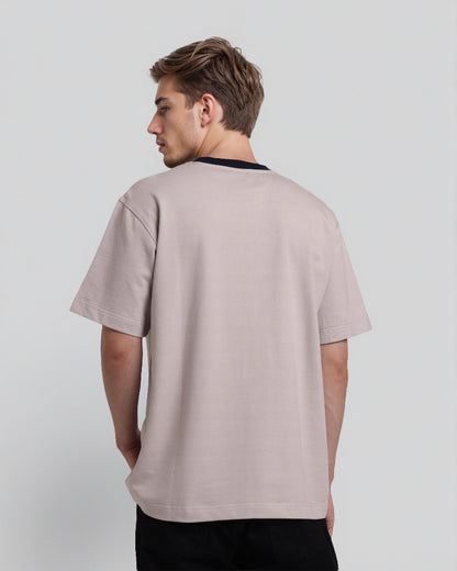 Man wearing a light gray t-shirt on a plain background