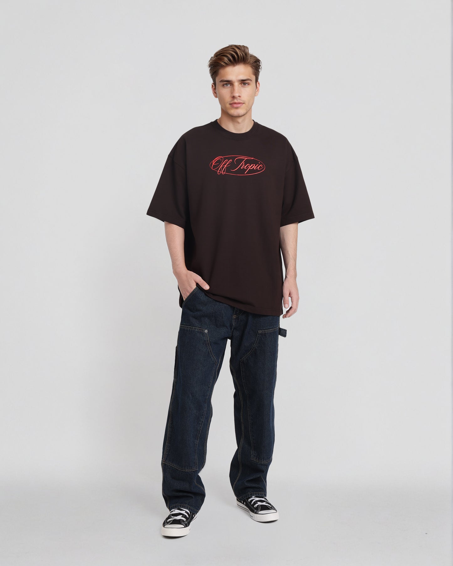 Person wearing a black t-shirt with red text and dark jeans on a white background