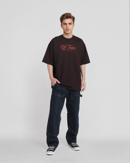 Person wearing a black t-shirt with red text and dark jeans on a white background